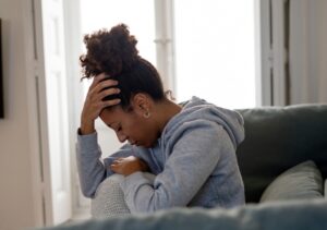 Black woman holds hand to head, to illustrate how cannabis may be able to help manage depression