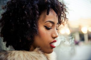 Black woman smoking, to illustrate tips for how to vape cannabis safely