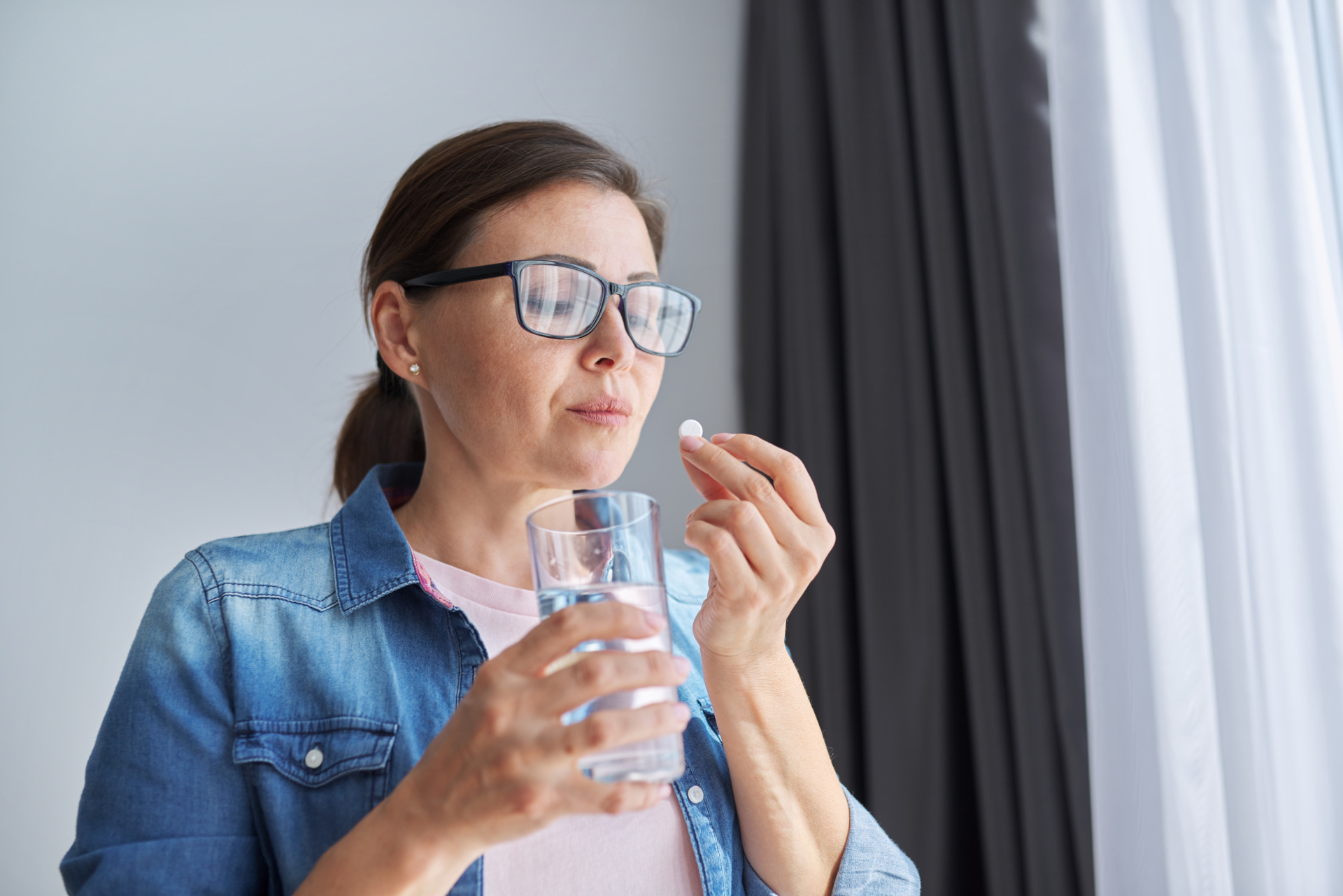 Middle-aged woman taking supplements to boost mental health