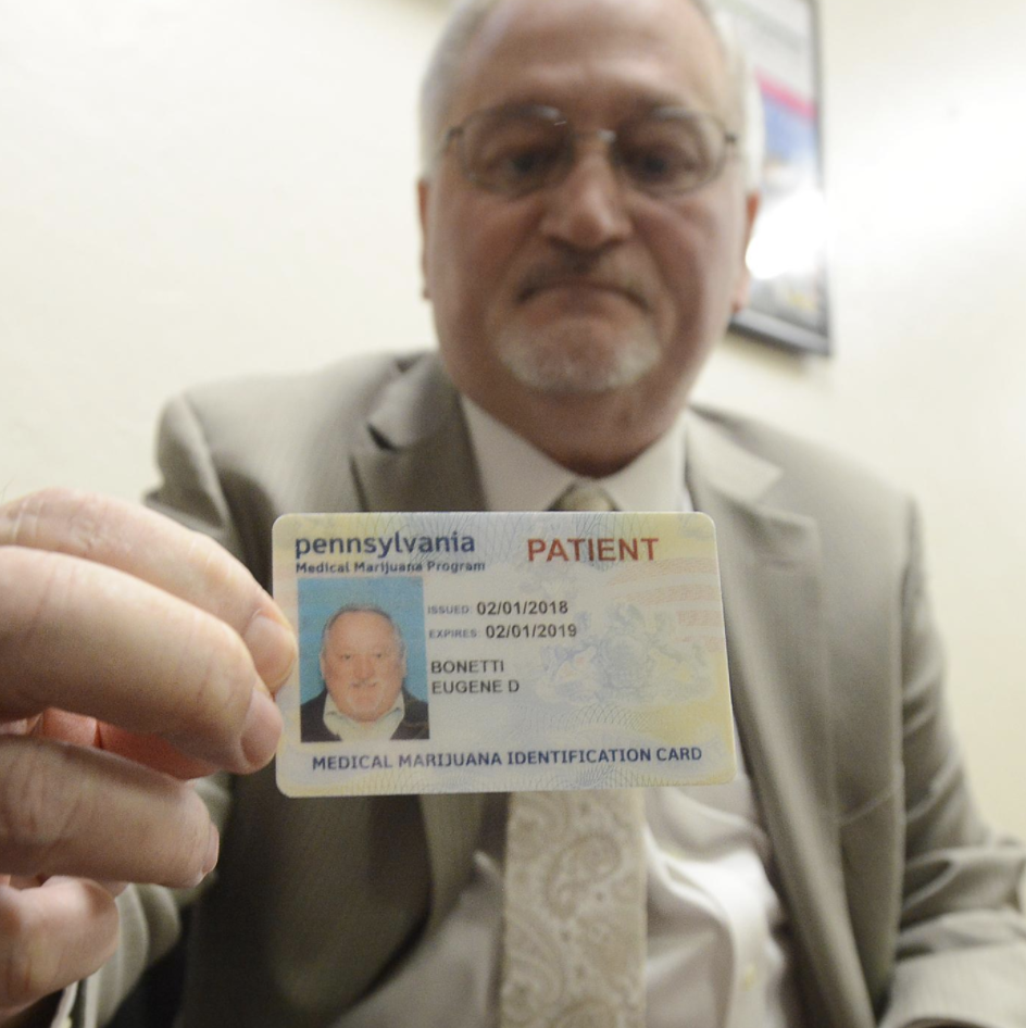 A patient holds his medical marijuana card in Pennsylvania