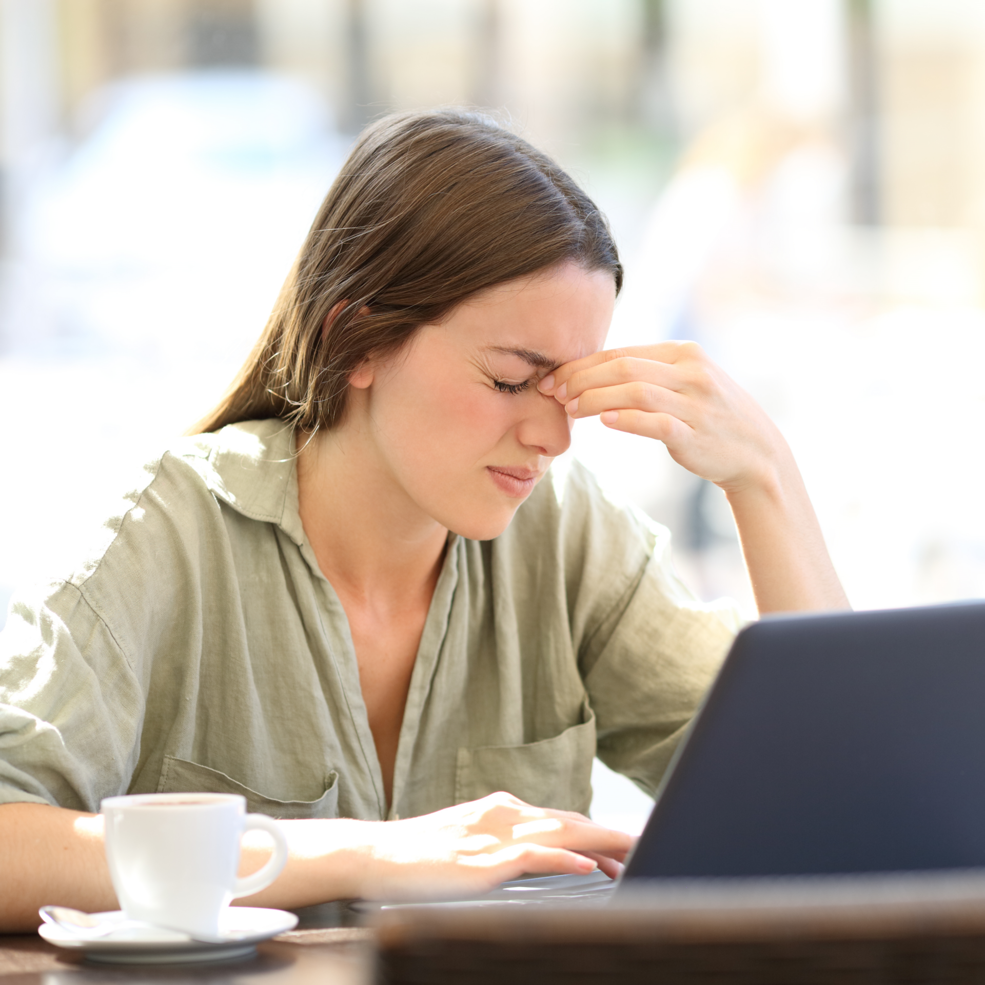 Woman grimacing with hand on forehead