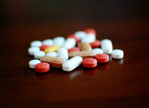 Colourful traditional therapy pills on a dark background, to illustrate how cannabis and hormones interconnect