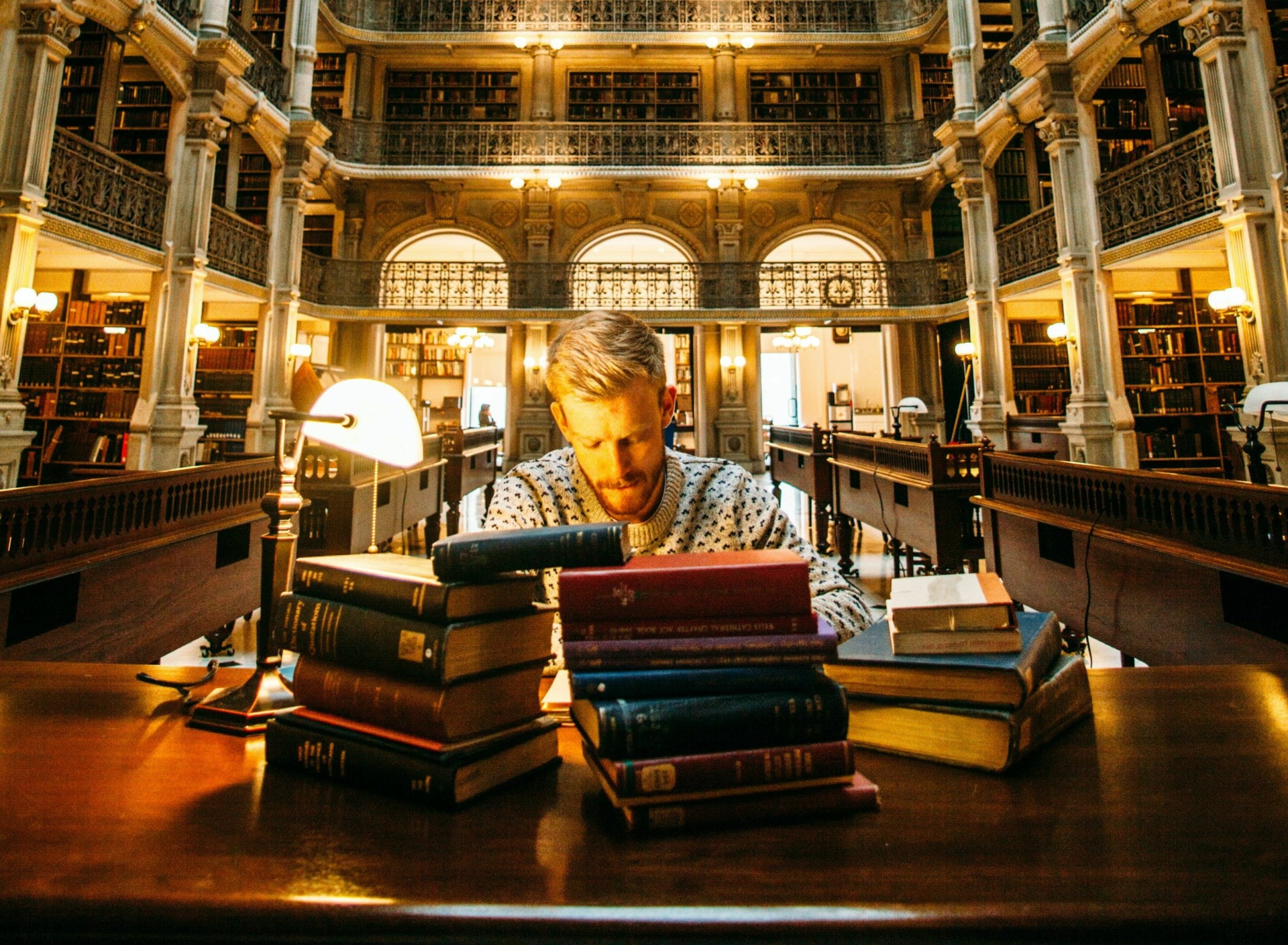 Man poring over books, to illustrate strains for productivity and efficiency