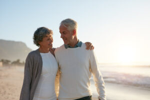 Mid-life couple walking on the beach, to illustrate the ECS and aging